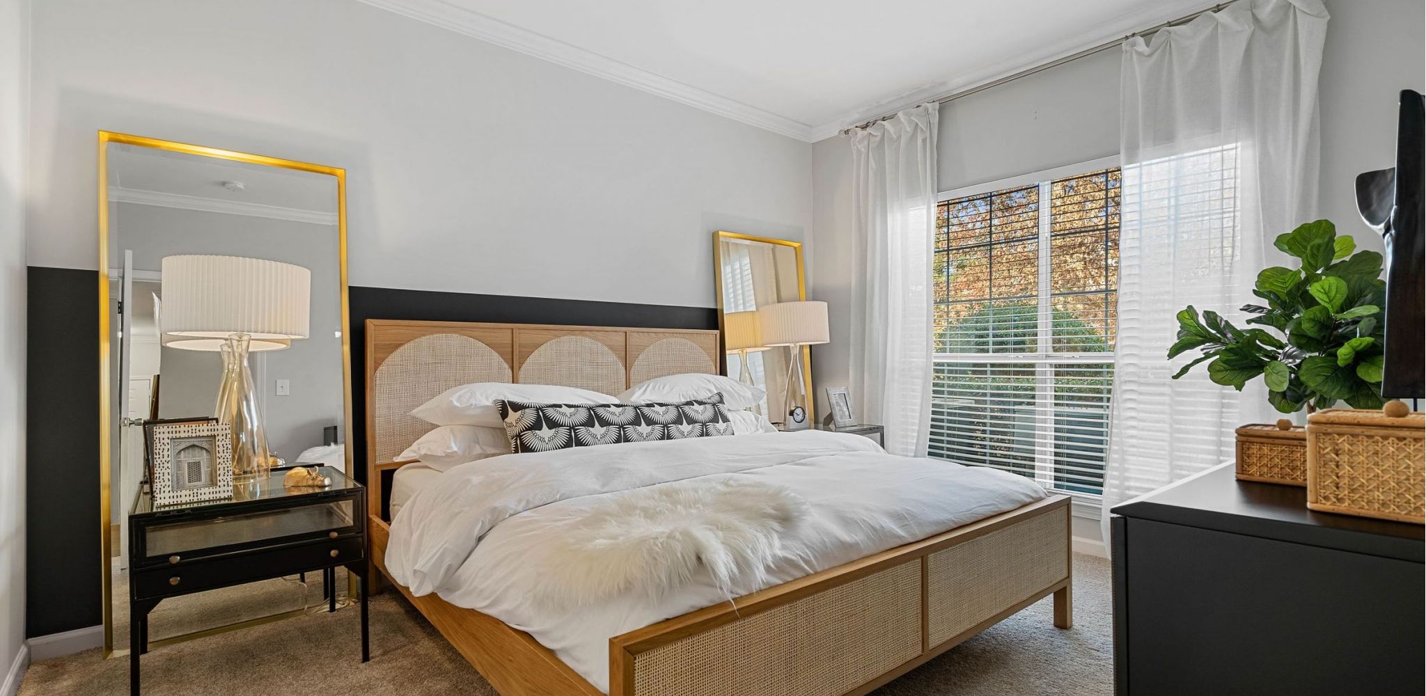 Hawthorne at the Carlyle spacious bedroom with large window and carpet floor.
